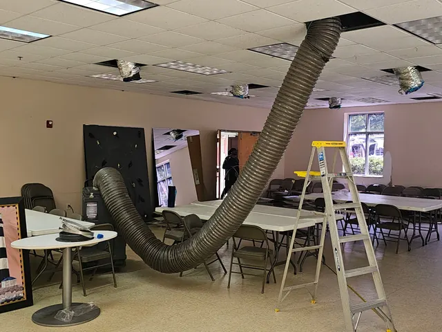 Vacuum hose run up to the ductwork in a meeting room