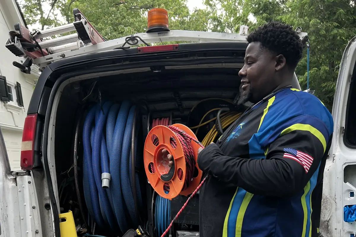 Fresh Cleaning Solutions technician at the company van with hose reels